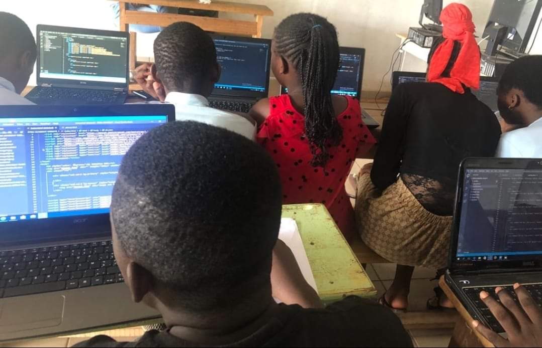 Young students writing code on laptops